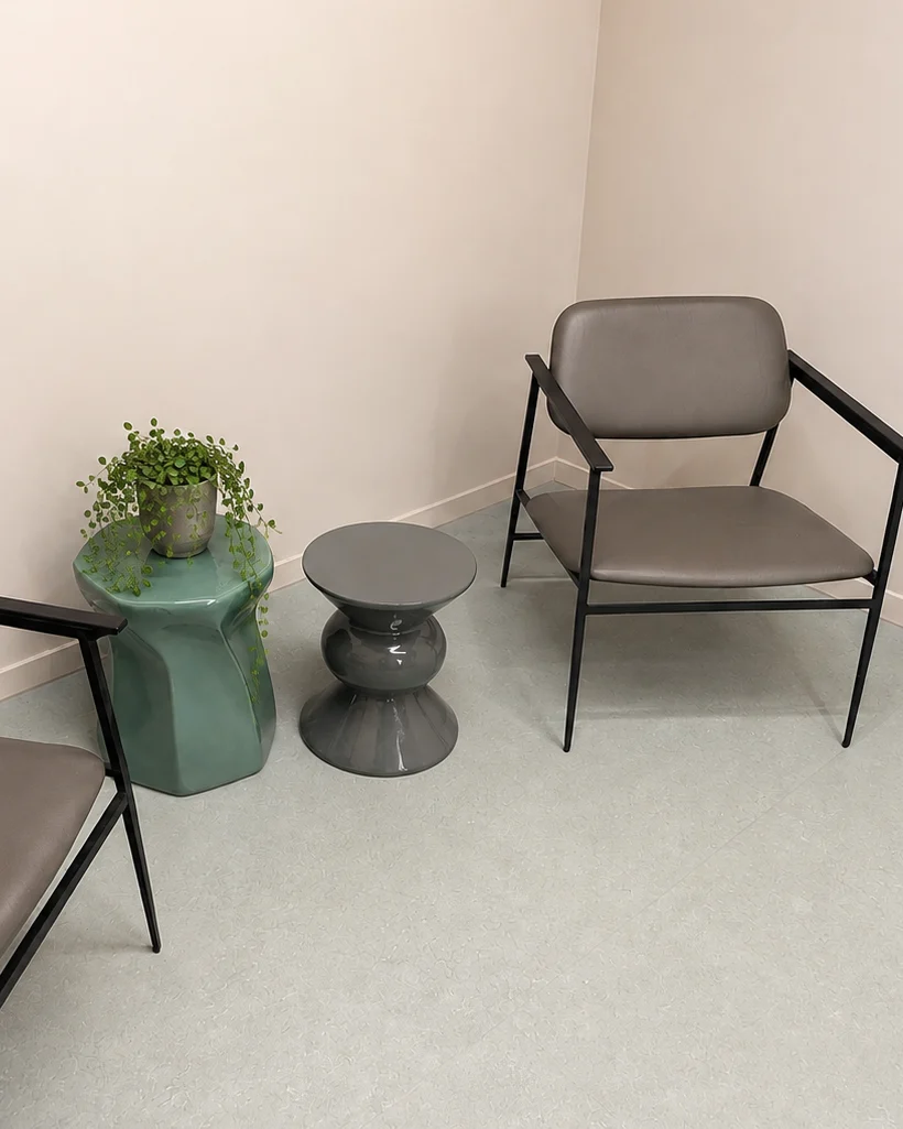 Wachtkamer van Praktijk Bios Wachtkamer van Praktijk Bios met stoelen en groene bijzettafeltjes.